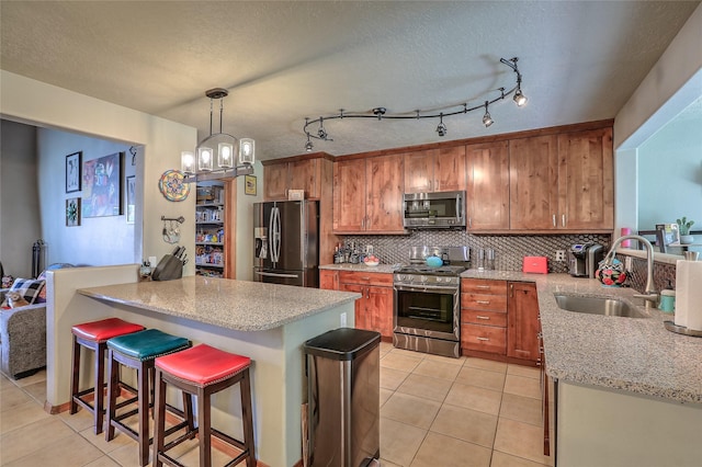 7513 Kachina Loop, Santa Fe, NM 87507 - kitchen featuring stainless steel appliances, a peninsula, light tile patterned floors, backsplash, and a breakfast bar area