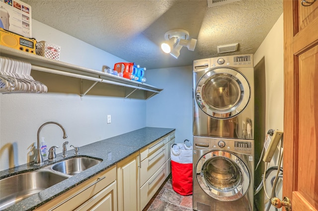 7513 Kachina Loop, Santa Fe, NM 87507 - laundry room featuring estacked washer and dryer, a textured ceiling, stone finish flooring, and cabinet space