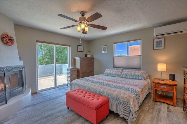7513 Kachina Loop, Santa Fe, NM 87507 - bedroom with a wall mounted air conditioner, access to exterior, wood finished floors, a textured ceiling, and ceiling fan