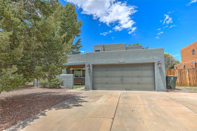 7513 Kachina Loop, Santa Fe, NM 87507 - pueblo-style home featuring concrete driveway, an attached garage, and stucco siding
