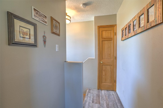 7513 Kachina Loop, Santa Fe, NM 87507 - hall featuring a textured ceiling, an upstairs landing, and wood finished floors
