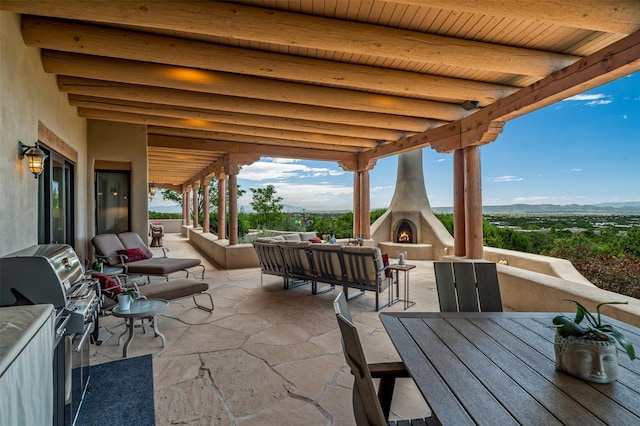 12 Sundance Ct, Santa Fe, NM 87506 - view of patio / terrace featuring an outdoor living space with a fireplace, a mountain view, and grilling area