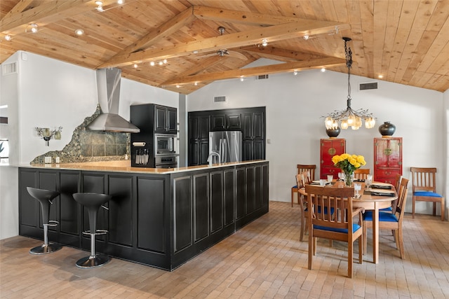 10 Sabina Ln, Santa Fe, NM 87508 - kitchen with wall chimney exhaust hood, dark cabinetry, a wood ceiling with exposed beams, appliances with stainless steel finishes, and a peninsula