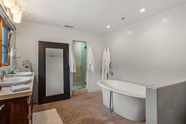 10 Sabina Ln, Santa Fe, NM 87508 - full bathroom with double vanity, a freestanding tub, recessed lighting, and brick patterned floors