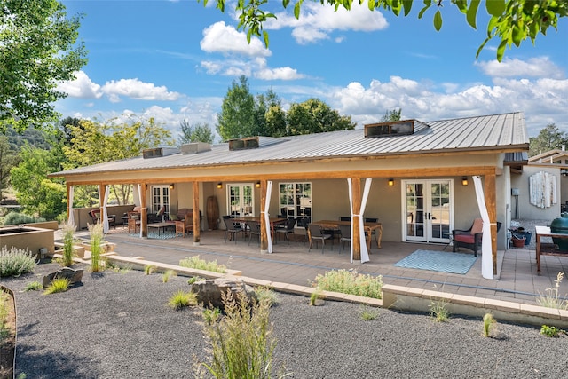 10 Sabina Ln, Santa Fe, NM 87508 - back of property featuring french doors, stucco siding, a metal roof, and a deck