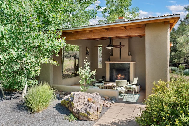 10 Sabina Ln, Santa Fe, NM 87508 - view of patio / terrace with a warm lit fireplace and ceiling fan