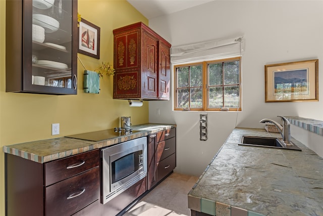 10 Sabina Ln, Santa Fe, NM 87508 - kitchen with stainless steel microwave, black electric cooktop, glass insert cabinets, and light countertops