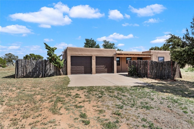 79 Moya Rd, Santa Fe, NM 87508 - view of front of house with driveway, an attached garage, and stucco siding