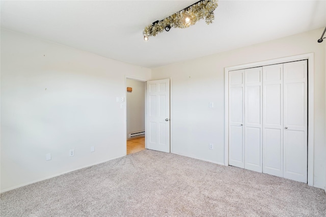 79 Moya Rd, Santa Fe, NM 87508 - unfurnished bedroom featuring light carpet, a baseboard radiator, and a closet