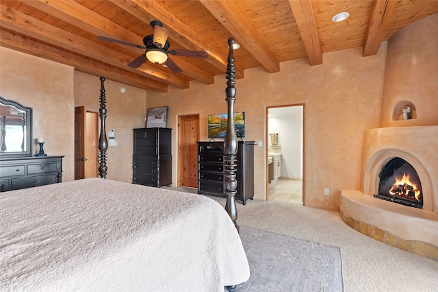 17 Sueno De Santa Fe, Santa Fe, NM 87505 - bedroom with carpet floors, a wood ceiling with exposed beams, and a lit fireplace