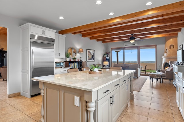 17 Sueno De Santa Fe, Santa Fe, NM 87505 - kitchen featuring stainless steel built in fridge, light tile patterned flooring, beam ceiling, open floor plan, and recessed lighting
