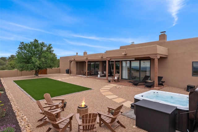 17 Sueno De Santa Fe, Santa Fe, NM 87505 - back of house with an outdoor fire pit, a hot tub, a patio area, a fenced backyard, and stucco siding