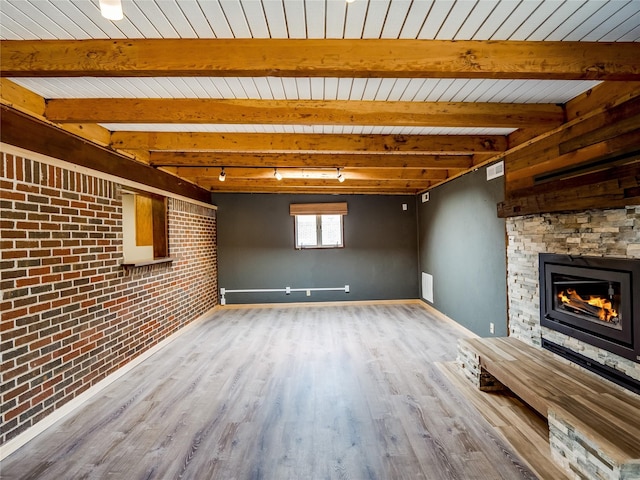 85 Chiquita Dr, White Rock, NM 87547 - unfurnished living room featuring a fireplace, wood finished floors, brick wall, rail lighting, and a wooden ceiling with exposed beams