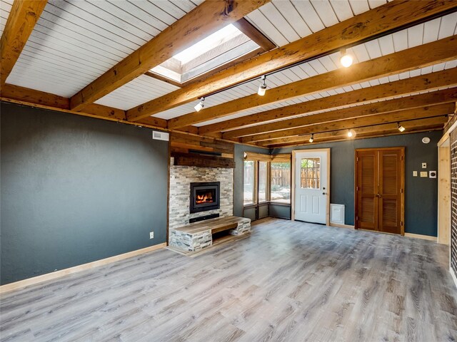85 Chiquita Dr, White Rock, NM 87547 - unfurnished living room with a skylight, wood finished floors, track lighting, a fireplace, and a wood ceiling with exposed beams