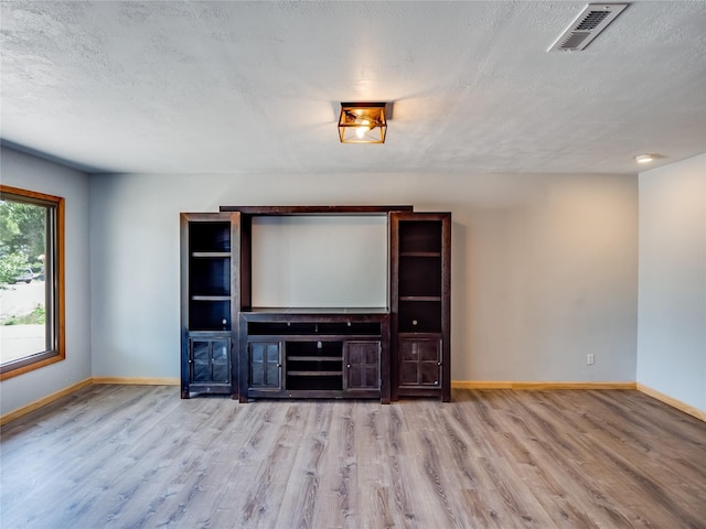 85 Chiquita Dr, White Rock, NM 87547 - unfurnished living room featuring wood finished floors and a textured ceiling