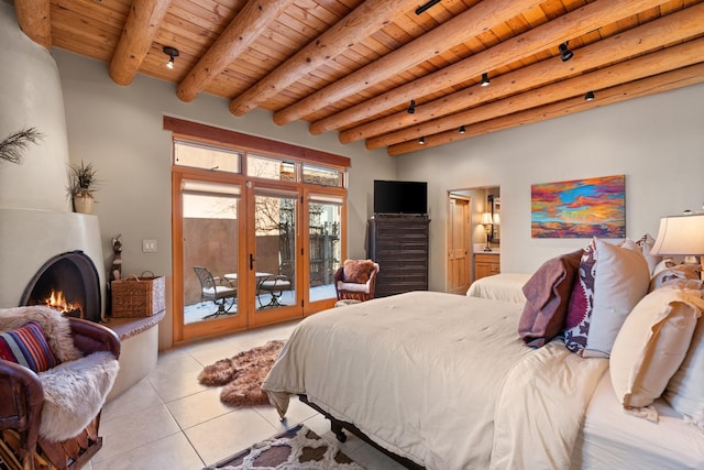 44 Lodge Cir Unit C, Santa Fe, NM 87506 - bedroom with a wood ceiling with exposed beams, access to exterior, light tile patterned floors, a lit fireplace, and french doors