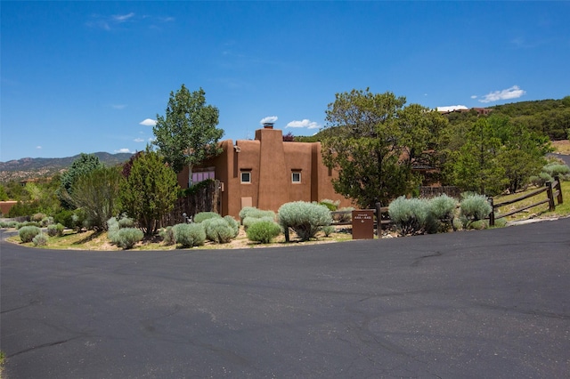 44 Lodge Cir Unit C, Santa Fe, NM 87506 - view of side of property with stucco siding, a chimney, and a mountain view