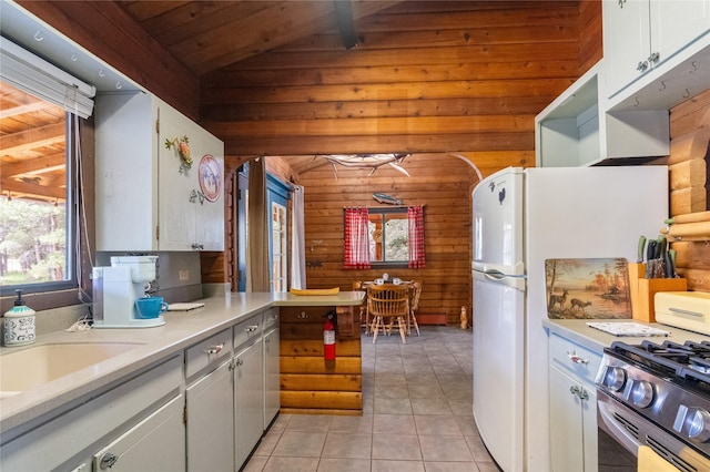 19 Canoe Ct, Jemez Springs, NM 87025 - kitchen with wooden walls, light tile patterned flooring, wooden ceiling, light countertops, and white cabinetry