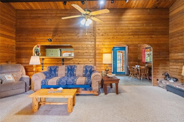 19 Canoe Ct, Jemez Springs, NM 87025 - carpeted living room with wooden ceiling, arched walkways, a ceiling fan, and wood walls