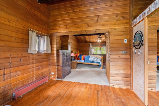 19 Canoe Ct, Jemez Springs, NM 87025 - unfurnished bedroom featuring baseboard heating, wooden walls, and wood finished floors
