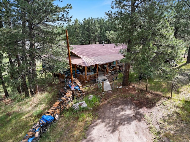 19 Canoe Ct, Jemez Springs, NM 87025 - view of front facade featuring a metal roof, a porch, a wooded view, and driveway