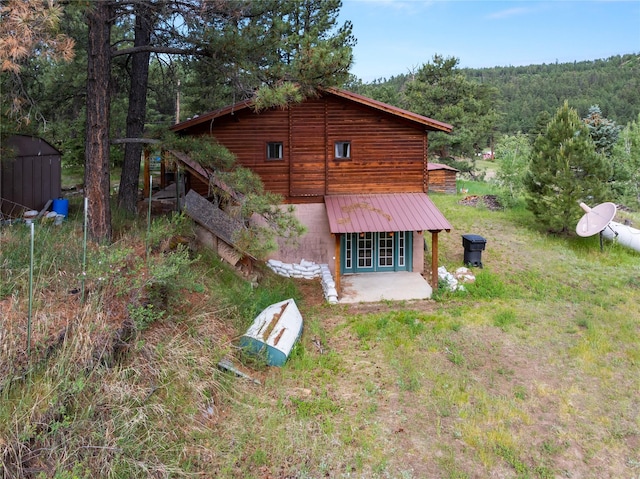 19 Canoe Ct, Jemez Springs, NM 87025 - rear view of property featuring french doors, a wooded view, and a patio area