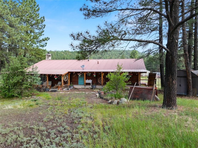 19 Canoe Ct, Jemez Springs, NM 87025 - view of front facade with a metal roof, covered porch, and a chimney