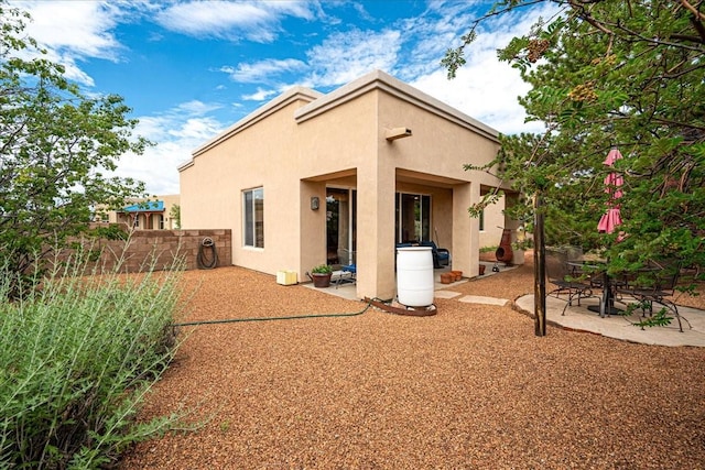 3 Hunters Run, Santa Fe, NM 87508 - rear view of house featuring stucco siding and a patio area