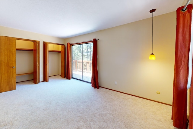 986 Alamo Rd, Los Alamos, NM 87544 - unfurnished bedroom featuring access to outside, light carpet, and two closets