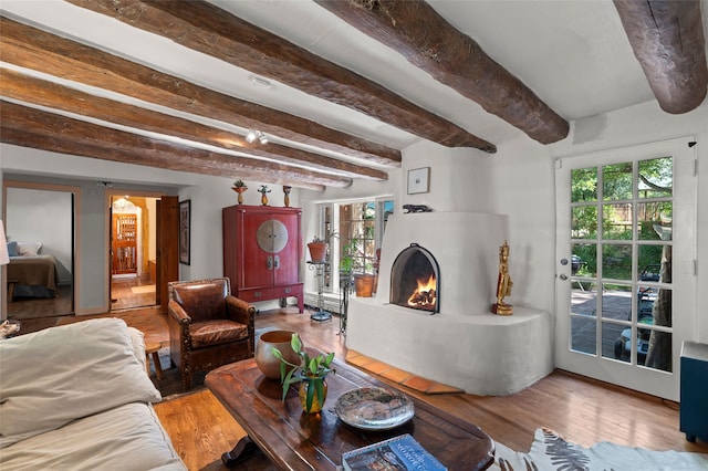 3B Camino Miguel, Santa Fe, NM 87506 - living area with a warm lit fireplace, beamed ceiling, wood finished floors, and healthy amount of natural light