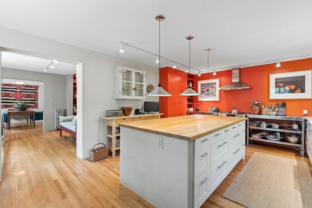 359 Garcia St, Santa Fe, NM 87501 - kitchen with track lighting, wall chimney exhaust hood, wooden counters, and radiator heating unit