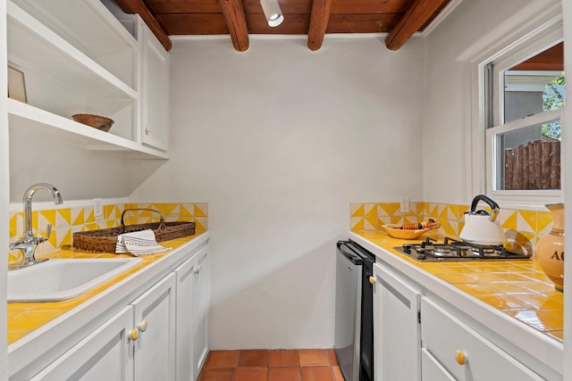 359 Garcia St, Santa Fe, NM 87501 - kitchen featuring tile countertops, decorative backsplash, stainless steel gas stovetop, white cabinets, and a wood ceiling with exposed beams