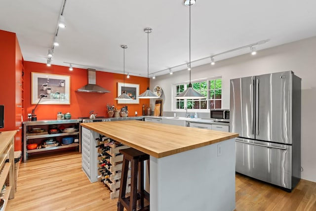 359 Garcia St, Santa Fe, NM 87501 - kitchen featuring track lighting, appliances with stainless steel finishes, wall chimney range hood, wooden counters, and light wood-type flooring