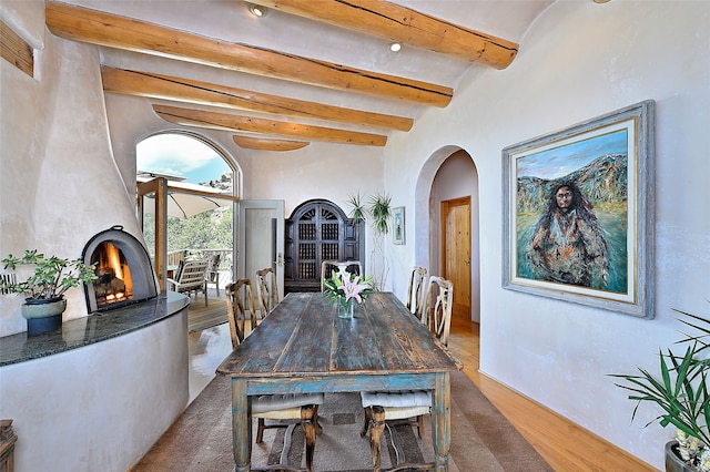 51 Coyote Mountain Rd, Santa Fe, NM 87505 - dining space featuring arched walkways, beam ceiling, and wood finished floors