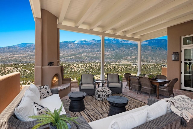 102 San Rafael Dr, Santa Fe, NM 87506 - wooden terrace featuring a mountain view and an outdoor living space with a fireplace