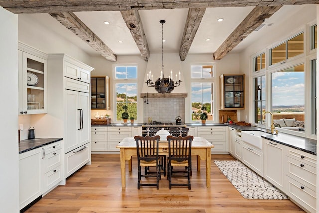 102 San Rafael Dr, Santa Fe, NM 87506 - kitchen featuring beam ceiling, high end appliances, a chandelier, light wood-type flooring, and glass insert cabinets