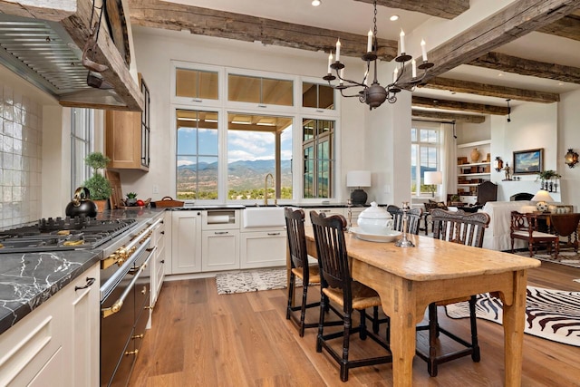 102 San Rafael Dr, Santa Fe, NM 87506 - dining area featuring beamed ceiling, light wood-style flooring, recessed lighting, a chandelier, and a mountain view