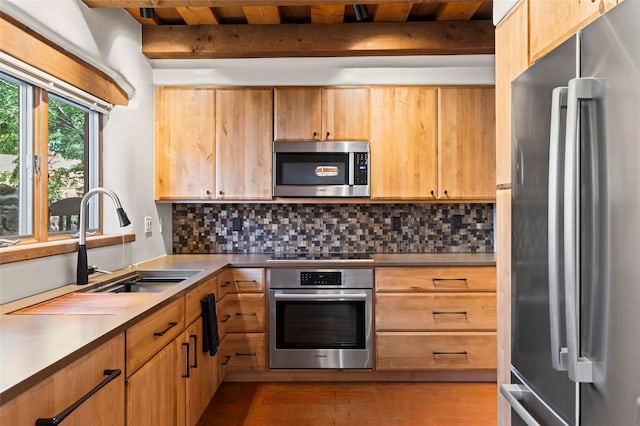 134 W Houghton St Unit D, Santa Fe, NM 87505 - kitchen featuring appliances with stainless steel finishes, tasteful backsplash, beamed ceiling, light countertops, and brick patterned flooring