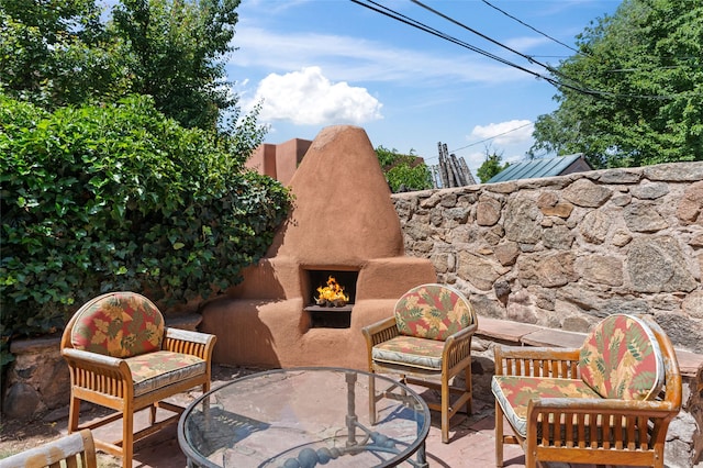134 W Houghton St Unit D, Santa Fe, NM 87505 - view of patio featuring a warm lit fireplace