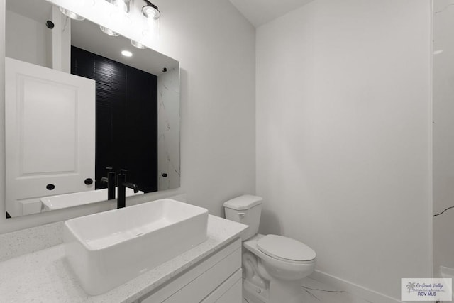 6245 Tiger Dr, Brownsville, TX 78521 - bathroom with toilet, vanity, and marble finish flooring