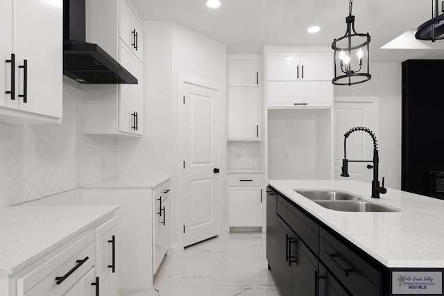 6245 Tiger Dr, Brownsville, TX 78521 - kitchen featuring wall chimney exhaust hood, a sink, recessed lighting, a kitchen island with sink, and light marble finish floors
