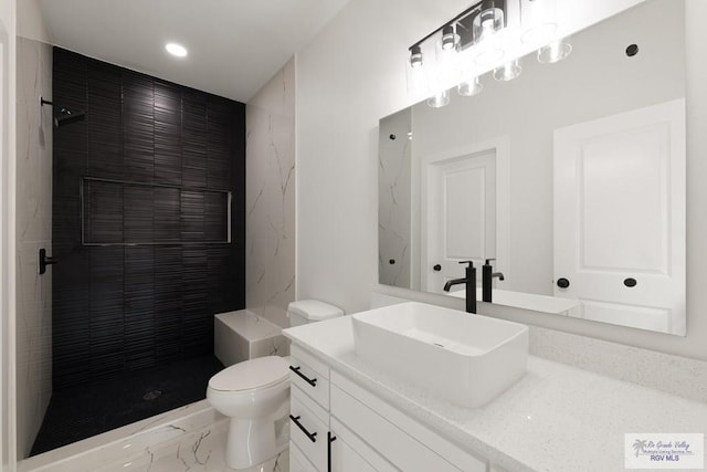 6245 Tiger Dr, Brownsville, TX 78521 - full bathroom with marble look tiles, toilet, vanity, a tile shower, and recessed lighting