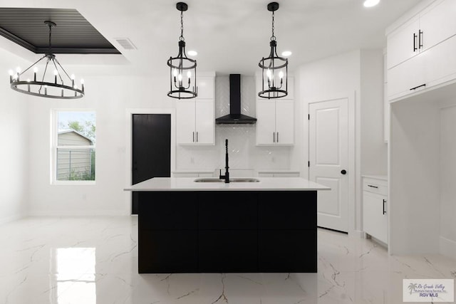 6245 Tiger Dr, Brownsville, TX 78521 - kitchen with wall chimney range hood, a sink, white cabinets, a center island with sink, and baseboards