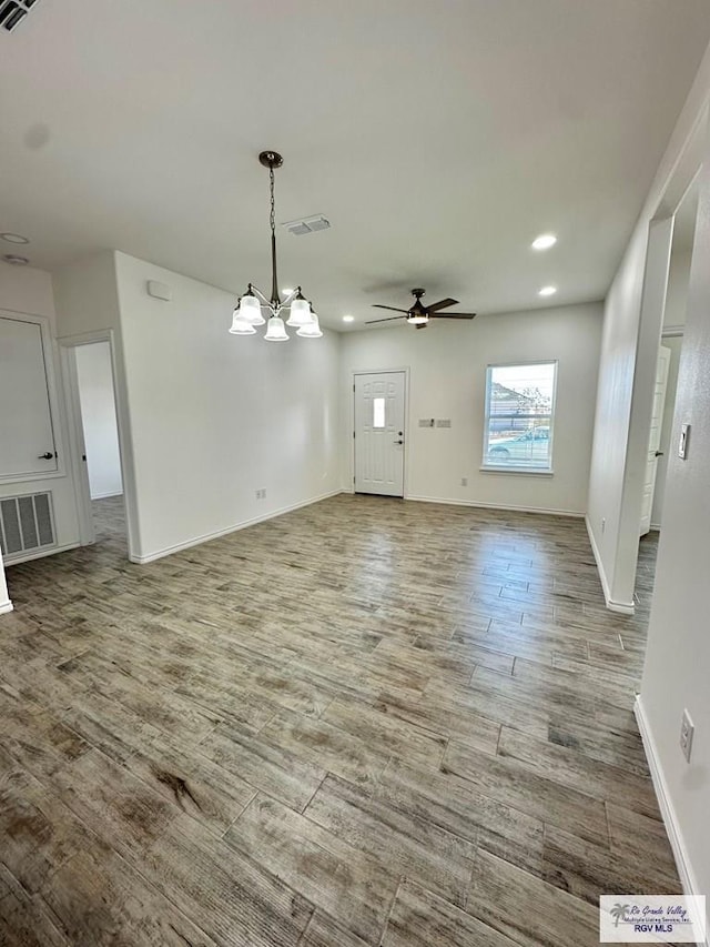 interior space featuring hardwood / wood-style flooring and ceiling fan with notable chandelier