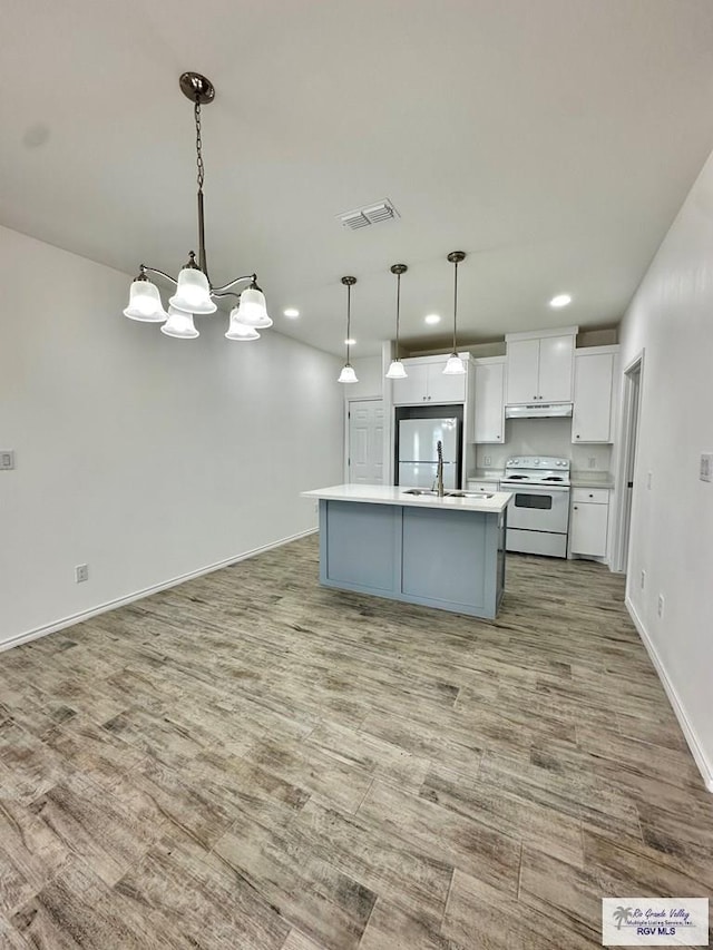 kitchen featuring decorative light fixtures, white electric stove, white cabinetry, built in refrigerator, and an island with sink