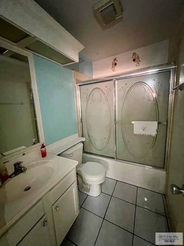 full bathroom featuring tile patterned flooring, vanity, shower / bath combination with glass door, and toilet