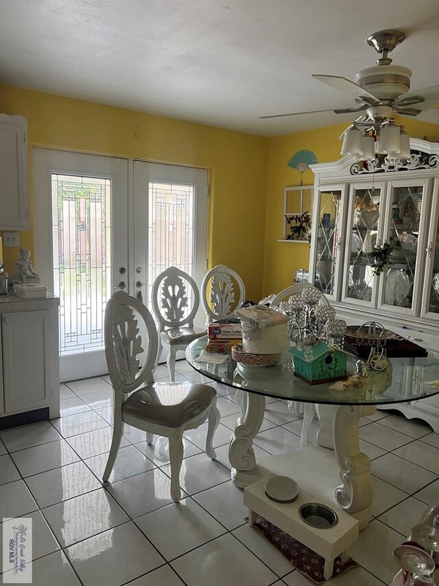 tiled dining space featuring ceiling fan and french doors