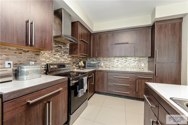 514 Hunt Ave, San Juan, TX 78589 - kitchen with light tile patterned floors, wall chimney exhaust hood, stainless steel appliances, dark brown cabinetry, and backsplash