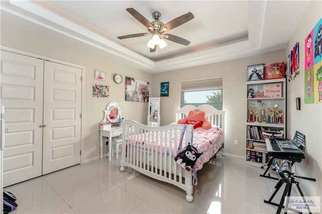 514 Hunt Ave, San Juan, TX 78589 - bedroom with a ceiling fan, a closet, a tray ceiling, baseboards, and tile patterned flooring