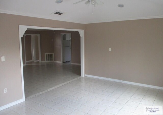 spare room with visible vents, baseboards, ornamental molding, and a ceiling fan